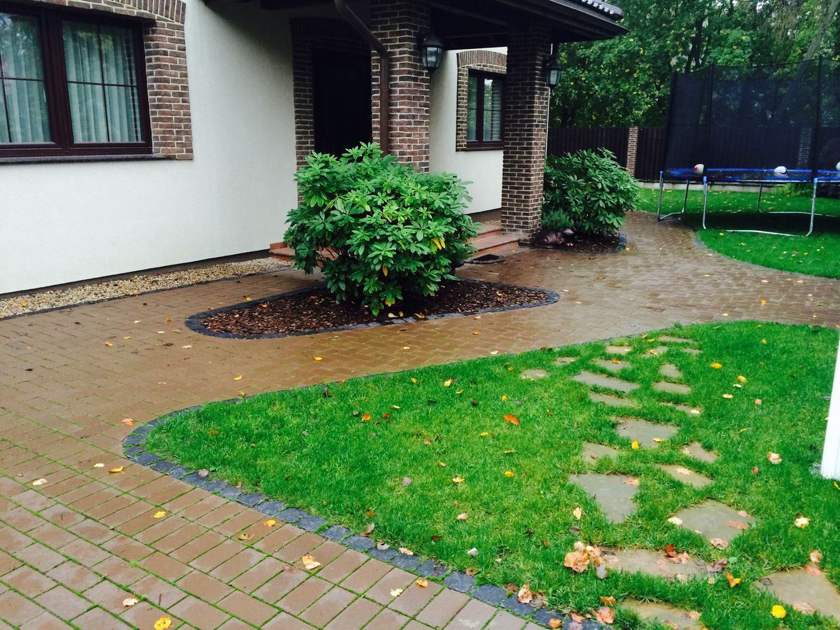 Namų aplinka su trinkelėmis ir laiptuojančiais akmenimis