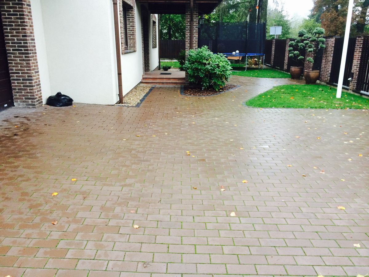 Didelis trinkelių kiemas su žalia veja